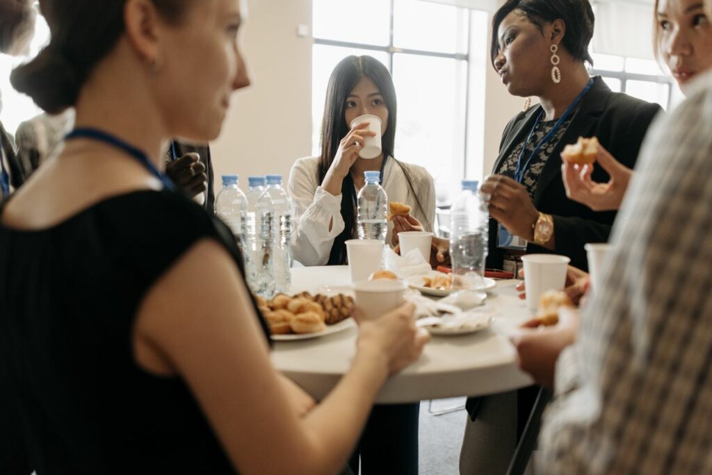 Group of diverse professionals networking over coffee and snacks during a business conference.