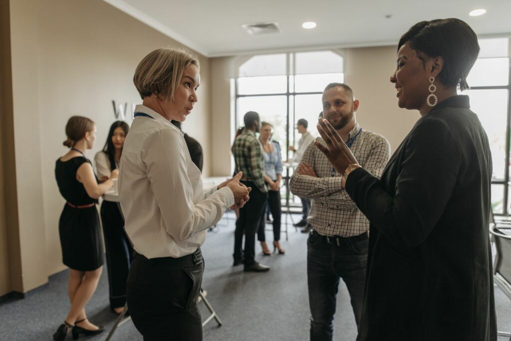 Professionals networking at a corporate event indoors, discussing and collaborating.
